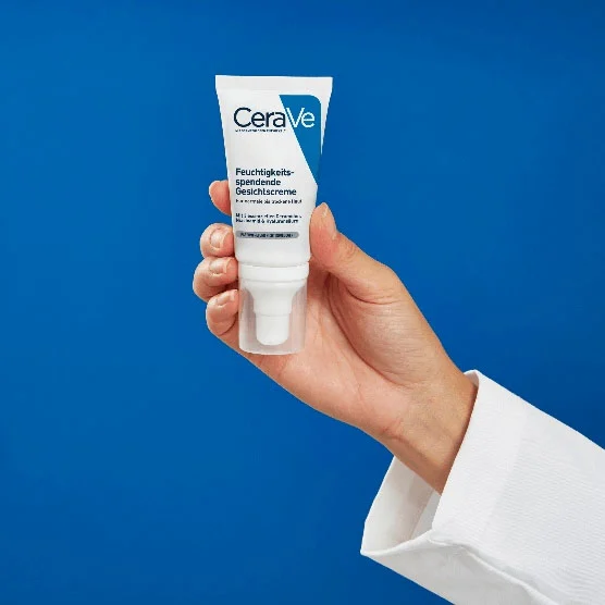 Peau sèche du corps : une main tient la CeraVe Crème Hydratante Visage 
